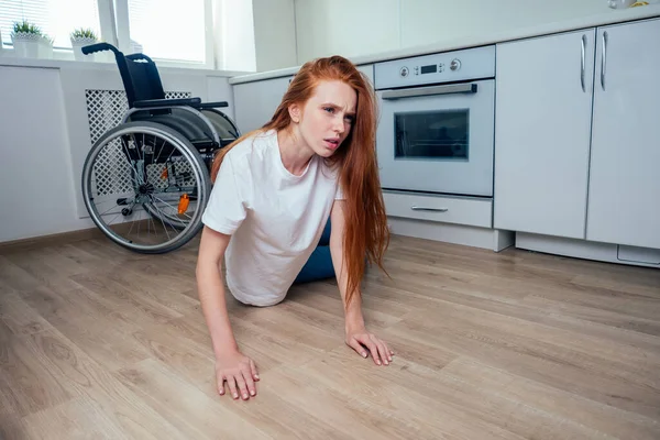 redhaired ginger woman falling down and crawling for help in kitchen room