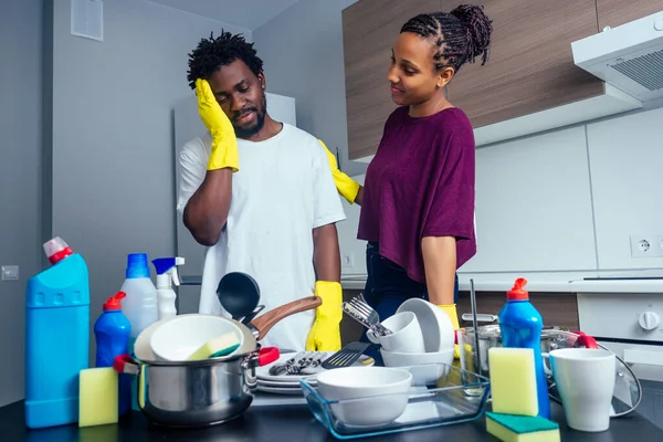 Infelice stanca coppia afroamericana in piedi vicino al tavolo pieno di piatti sporchi e tazze — Foto Stock