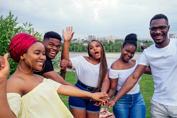 Group of five smiling african-american men and women walking outside cloudy weather near the lake,exchange students in Russia — Stock Photo, Image