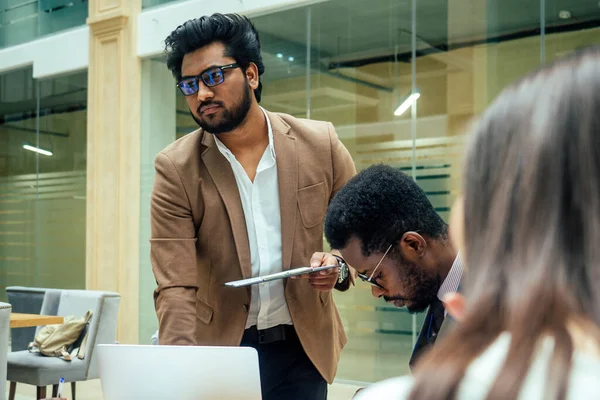 Homens indianos de negócios bem vestidos fazendo um relatório para funcionários subordinados em um escritório moderno — Fotografia de Stock