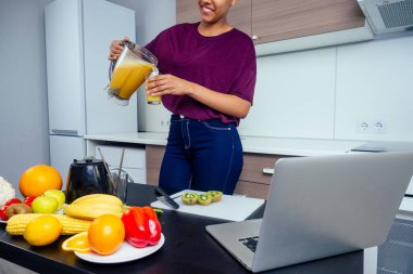 Meyve suyu barında çalışan Latin bir kadın muz, portakal ve kavundan taze meyve püresi yapıyor. Yeniden kullanılabilir eko metal tüpler ve cam kullanıyor.