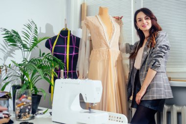 İşyerinde el yapımı boncuk işlemeli şeffaf tül dantel elbise diken bir kadın.