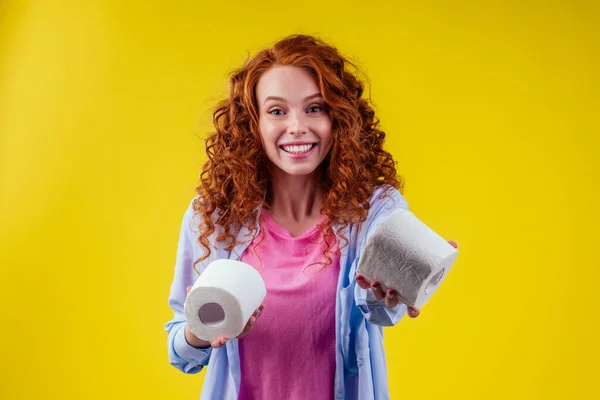 Bella rossa riccia zenzero donna scegliendo eco rotolo di carta igienica su sfondo di colore giallo — Foto Stock