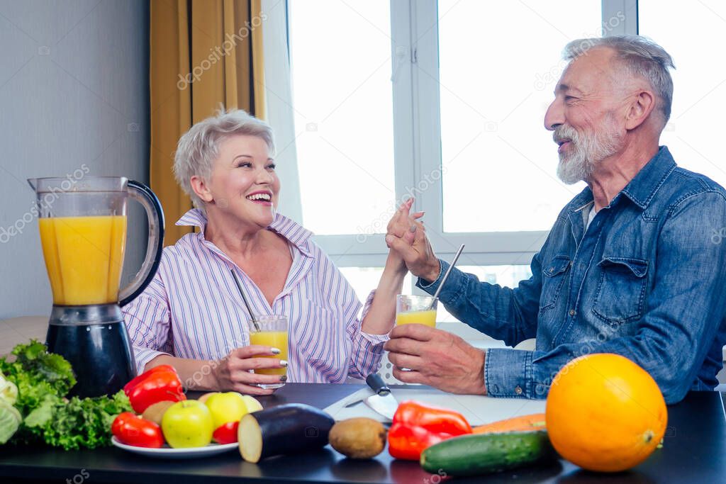 Senior couple drinking vegan smoothie with organic fruits and vegatables from eco glasses and reusable tubes,high five