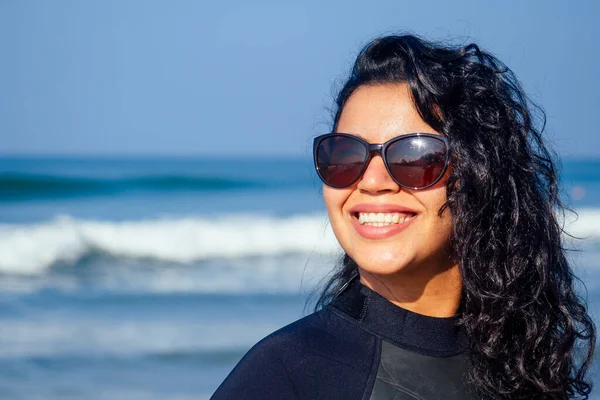 Милая индийская женщина в солнечных черных очках и гидрокостюме на пляже Гоа — стоковое фото