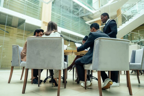 Homens afro-americanos de negócios bem vestidos fazendo um relatório para funcionários subordinados em um escritório moderno — Fotografia de Stock