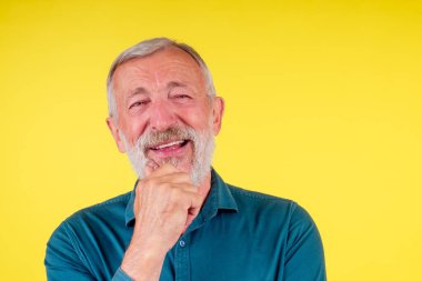 Yakışıklı, mutlu, olumlu ve tatmin edici, iyi kar beyazı dişler. Sahte diş stüdyoları sarı arka plan.