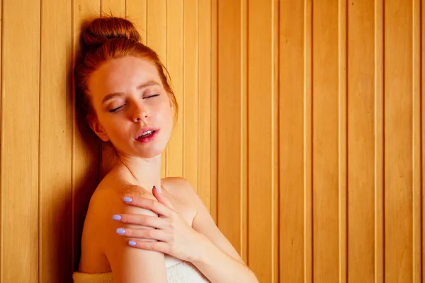 Pelirroja mujer de jengibre relajándose en una sauna rusa banya mimándose, concepto de amor propio — Foto de Stock