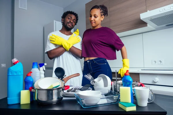 Infelice stanca coppia afroamericana in piedi vicino al tavolo pieno di piatti sporchi e tazze — Foto Stock