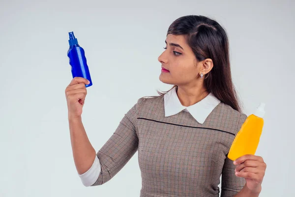 Индийская женщина держит бутылку крема для загара на белом фоне студии — стоковое фото