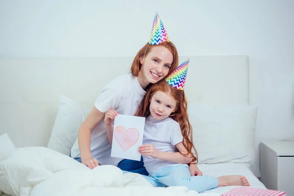 Muttertag. Mädchen schenkt ihrer Mutter eine Postkarte. — Stockfoto