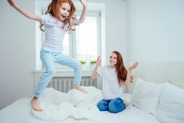 Anne ve kız evdeki yatakta zıplıyorlar. başarı kavramı — Stok fotoğraf