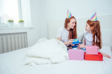 Kız annesine evde bir hediye veriyor. mutluluk ve neşe konsepti