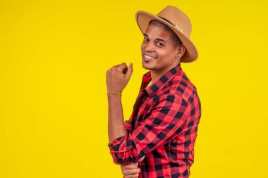 Stüdyoda sarı arka planda poz veren Arap asıllı bir adam.