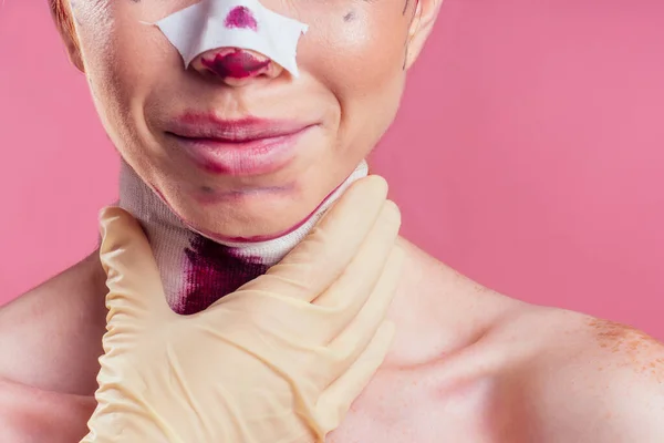 Pasien dalam perban. Perawat dan wanita muda di studio latar belakang merah muda — Stok Foto
