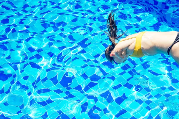 Hermosa joven mujer sin brazos de entrenamiento para nadar en la piscina en el complejo tropical — Foto de Stock