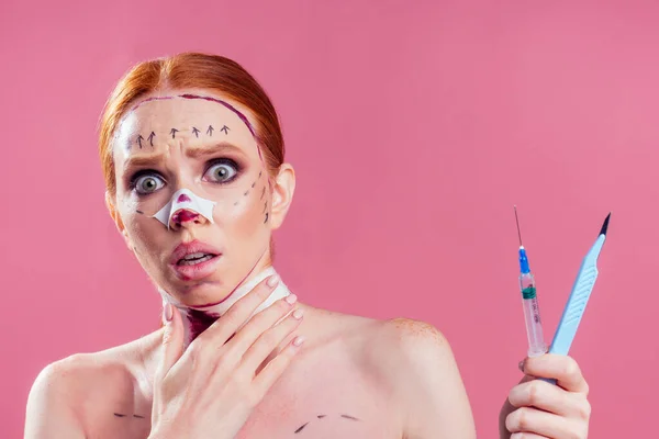 Kaukasisk panik kvinnlig kosmetiska lyft förfarande i studio rosa bakgrund — Stockfoto