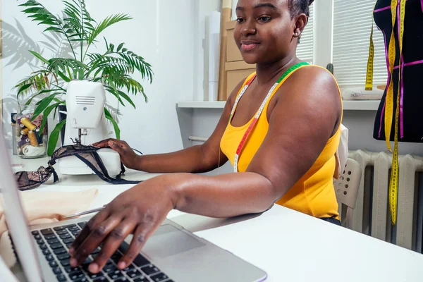 Žena módní návrhářka s afro pigtails dredy pracuje na svém domácím ateliéru — Stock fotografie