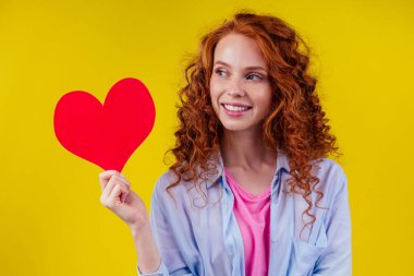 Kardiyolog kızıl bukleli mutlu kadın stüdyo sarı arka planda duyuldu.