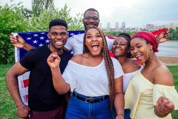 Group of girls and boys smiling with American flag in spring park autumn evening learning English language exchange students