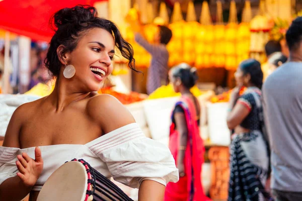 Индиец в модной одежде, позирующий на азиатском базаре, играющий на джамбе — стоковое фото