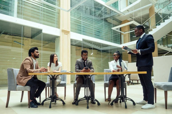 Well-dressed business afro american men making a report to subordinate employees in a modern office — Stock Photo, Image