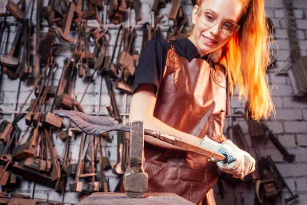 Roodharige roodharige jonge Europese feministische vrouw draagt lederen schort werken smid workshop.small business sterk en onafhankelijk concept — Stockfoto