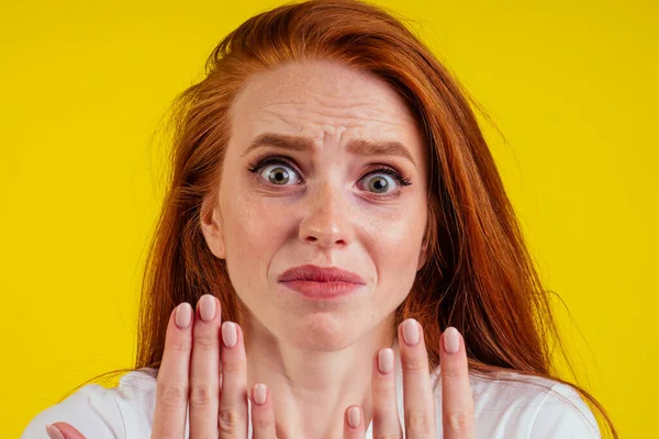 Primo piano ritratto di nervoso infelice giovane donna rossastra zenzero guardando una unghia rotta e piangendo .manicure nuda in studio sfondo giallo — Foto Stock