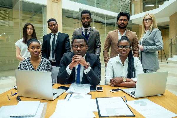 Un grupo de exitosos afroamericanos, europeos, empresarios árabes y coreanos que trabajan en la oficina con grandes ventanales de vidrio —  Fotos de Stock