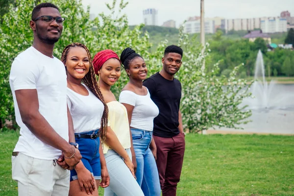 Group of five smiling african-american men and women walking outside cloudy weather near the lake,exchange students in Russia — Stock Photo, Image