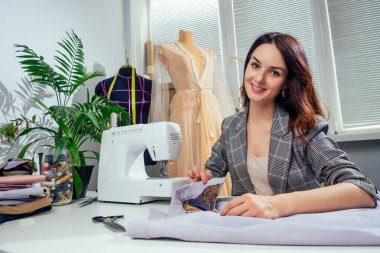 Moda tasarım stüdyosu. Manken mankeni ve dikiş makinesi fotokopi makinesi maketi olan tropikal palmiye bitkisi.