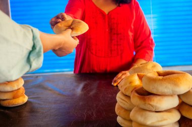 Mutlu Hintli kadın pazarda taze geleneksel çörekler sallıyor.