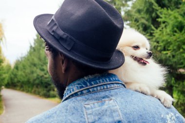 Afro adam parkta tükürük tükürüğüne sarılıyor.