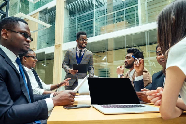 Well-dressed business afro american men making a report to subordinate employees in a modern office — Stock Photo, Image