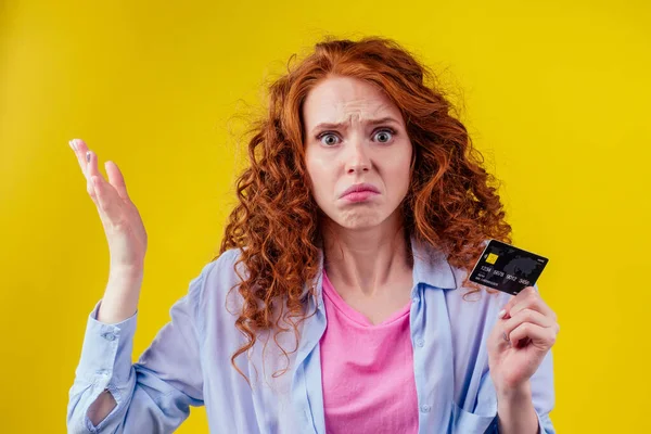 Запутавшийся рыжеволосый кудрявый рыжий женщина холодные пластиковые кредитные карты и глядя upsad .rejection концепции — стоковое фото