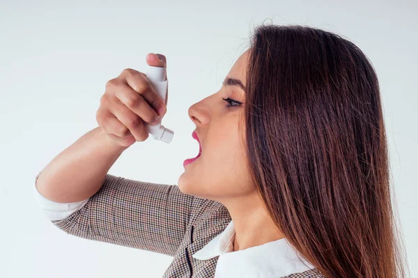 Hombre indio joven en un suéter de punto cálido y cuello blanco con inhalador de asma en el estudio blanco background.businesswoman enfermedad en el trabajo en otoño — Foto de Stock