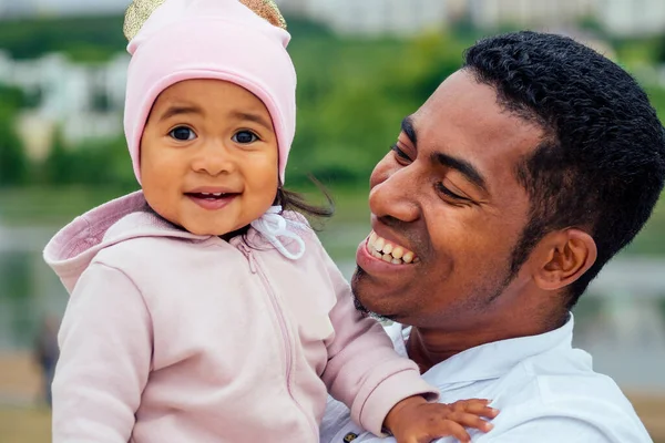 Afro padre abrazando su mestiza hija pasando tiempo en jardín — Foto de Stock