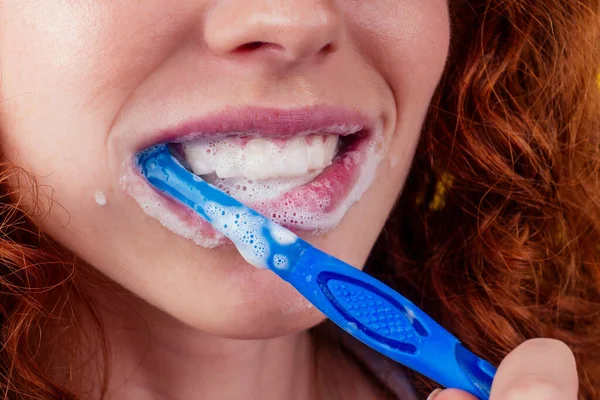 Rudowłosy imbir kobieta mycie zębów z pastą do zębów eco pasta na żółtym tle studio — Zdjęcie stockowe
