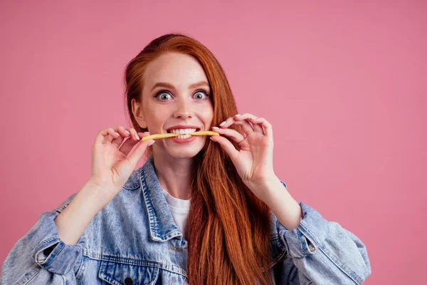 Lustige rothaarige Ingwerfrau mit Kartoffeln wie Hundezahnangst, ihre Hände wollen dich im rosafarbenen Hintergrund ergreifen. Angstbonbons oder Lebenskonzept — Stockfoto