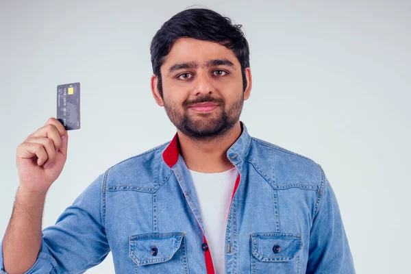 Šťastný indický muž držící kreditní kartu ve studiu bílé pozadí — Stock fotografie