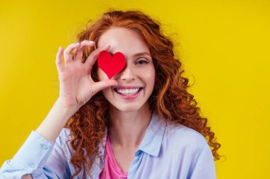 Kardiyolog kızıl bukleli mutlu kadın stüdyo sarı arka planda duyuldu.