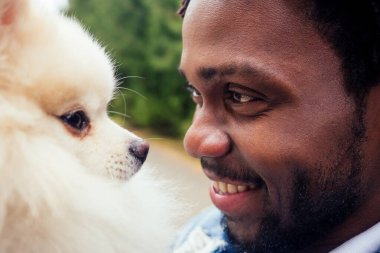 Afro adam parkta tükürük tükürüğüne sarılıyor.