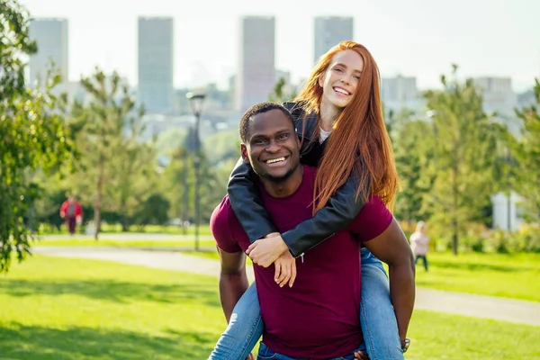 Retrato del joven abrazando a su novia de pie juntos en un parque de verano de primavera en un día soleado — Foto de Stock