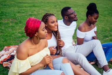 Keyifli Amerika Afrikalı insanlar dışarıda hamburger yiyip eğleniyor. Öğrenciler tatilde. Yaz akşamı hava bulutlu.