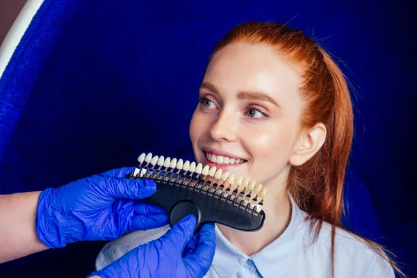 Vörös hajú gyömbér fiatal vidám női ügyfél ül a fogorvosi rendelőben, és egyre mosoly fehérítő tojásszék — Stock Fotó