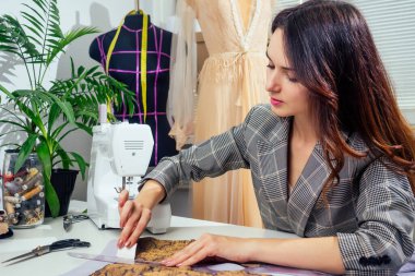 Dikiş atölyesinde çalışan kareli ceketli bir terzinin portresi.