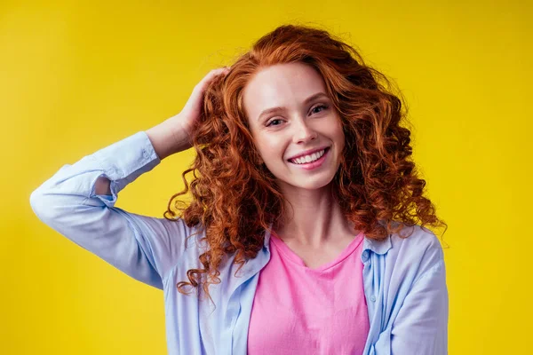 hair loss treatment prevention concept. luxury volume curly redhead ginger young woman proud her lions mane studio yellow background
