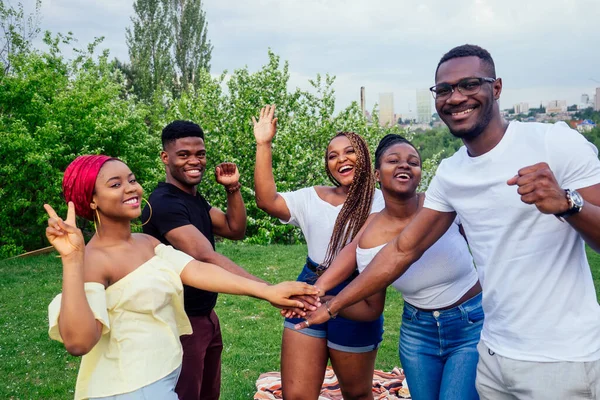 Group of five smiling african-american men and women walking outside cloudy weather near the lake,exchange students in Russia — Stock Photo, Image