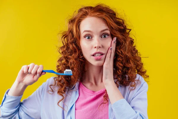 Pelirroja jengibre mujer cepillarse los dientes con pasta de dientes eco pasta en amarillo fondo del estudio — Foto de Stock