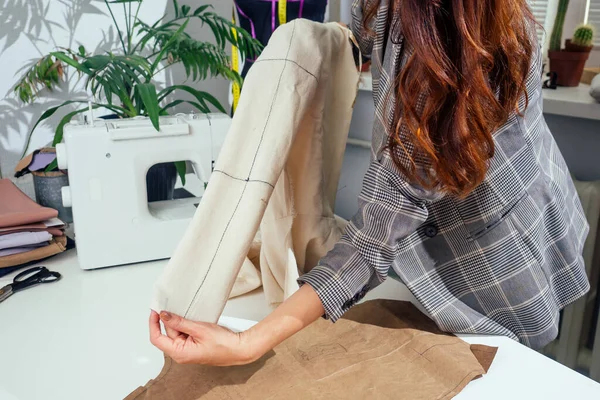Krawiecka kobieta mierząca rękaw za pomocą miernika taśm, pracująca w pracowni krawieckiej pokazującej idealny układ kurtki bawełniana maquette — Zdjęcie stockowe